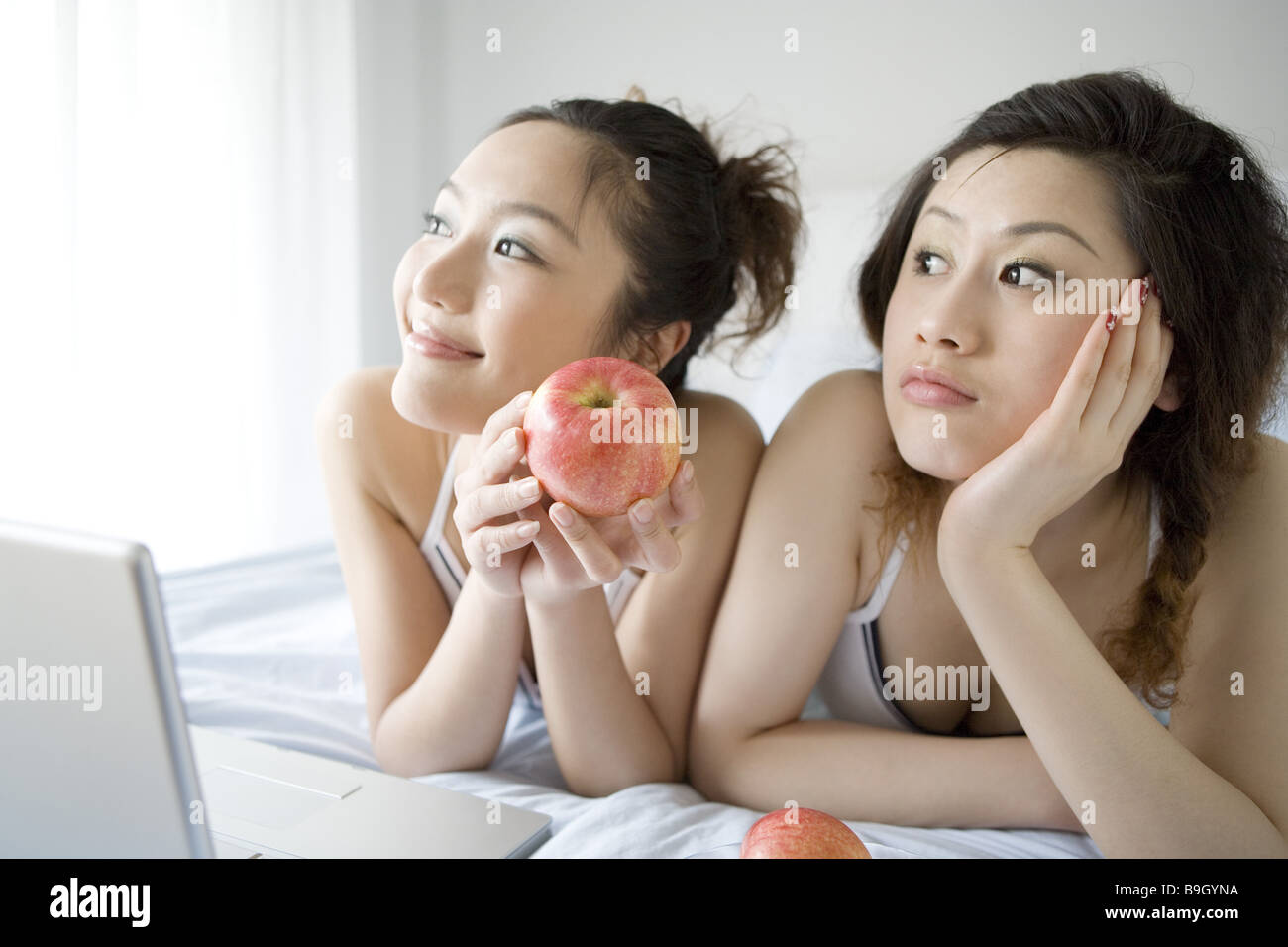 Due giovani donne giacente sul letto ritratto Foto Stock