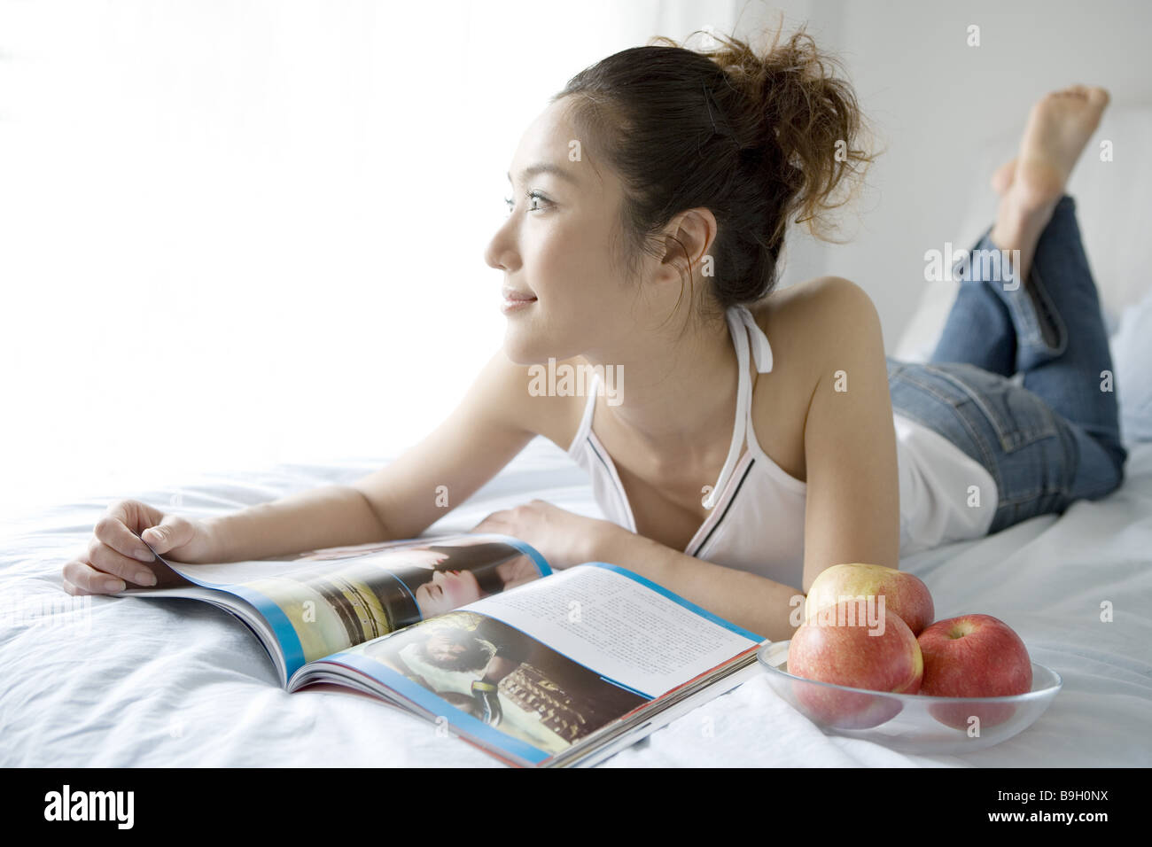 Una giovane donna giaceva sul letto Foto Stock