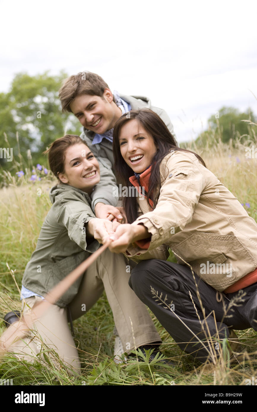 Gruppo Tug-of-War corda si muove sorridente tempo libero la natura al di fuori di 20-30 anni di attività endurance vivacità all'esterno esterno Foto Stock