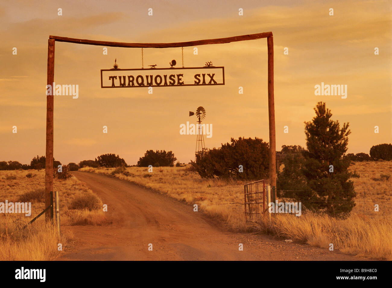 Cartello in ferro battuto al cancello del ranch in legno al tramonto vicino a Los Cerrillos sul Turquoise Trail nel New Mexico, USA Foto Stock