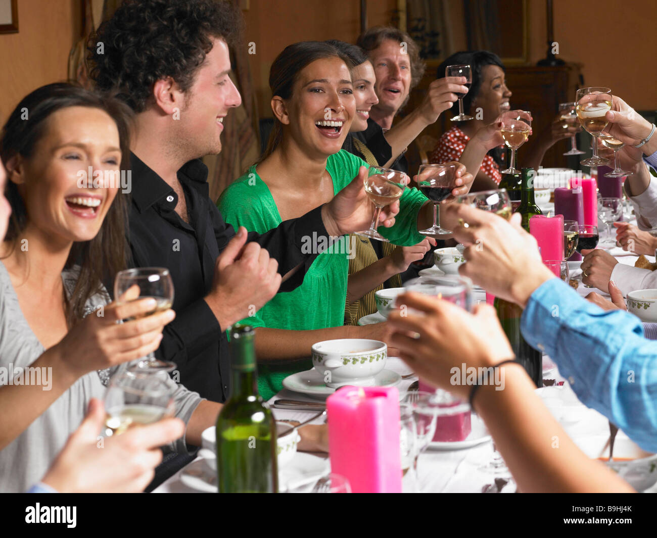 Persone tostare i loro bicchieri a cena Foto Stock