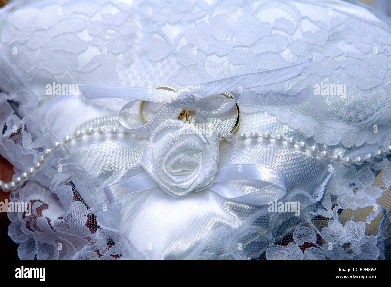 Gli anelli di nozze su un decorativo cuscino bianco Foto Stock