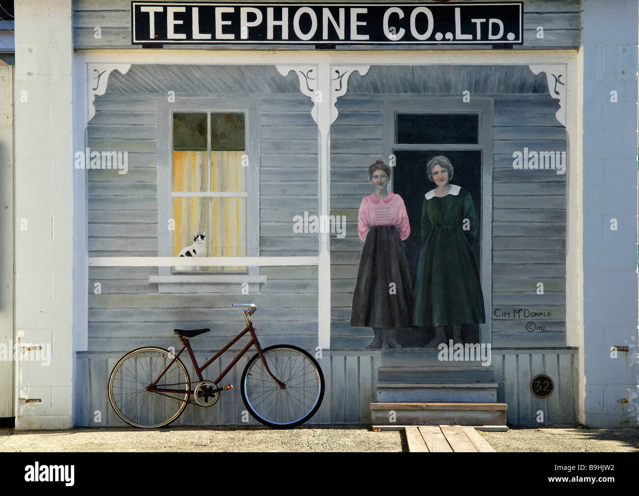 Casa con due donne gli operatori telefonici, grande murale con una bicicletta appoggiata contro di esso, Chemainus nei pressi di Nanaimo, Isola di Vancouver, Foto Stock