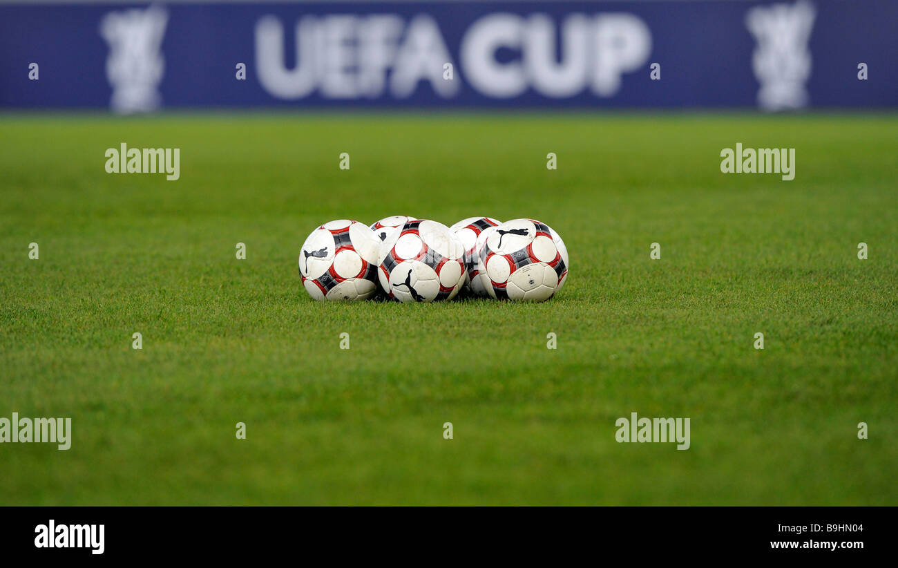 Palloni da calcio su un campo di calcio, nella parte anteriore del perimetro pubblicità con il logo della UEFA-Cup Foto Stock