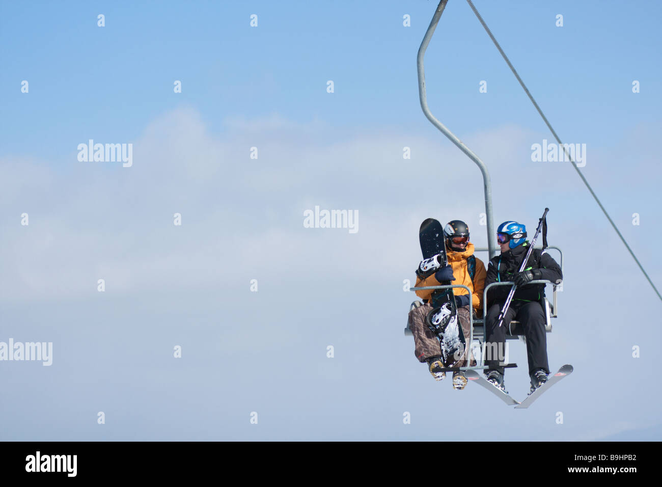 Gli sciatori su un impianto di risalita fino al monte Foto Stock
