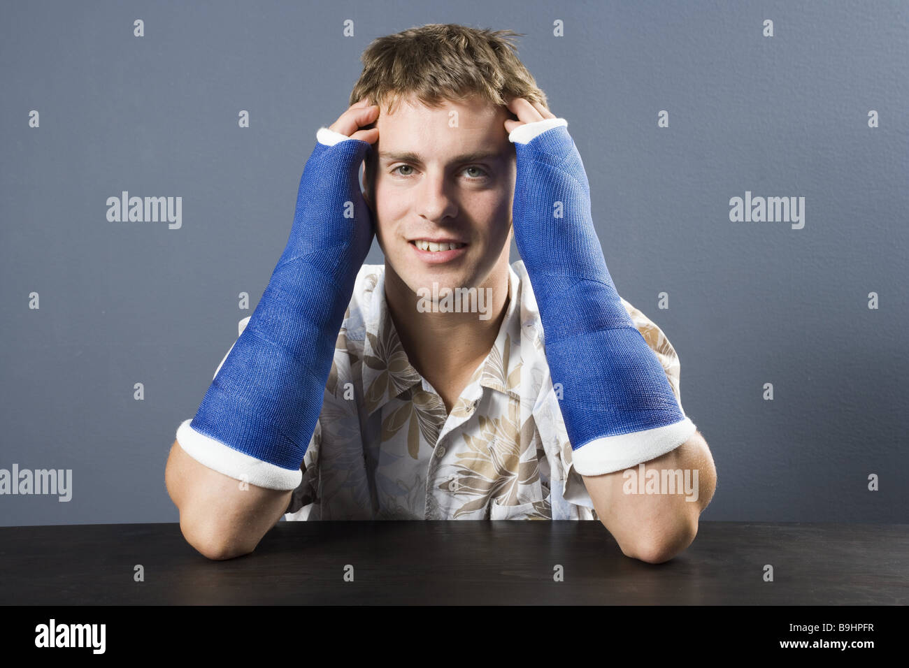 L uomo del braccio in gesso ritratto sorridente serie bracci persone ferite fratture braccio-breaks intonacato in calchi in gesso ostacolo Foto Stock