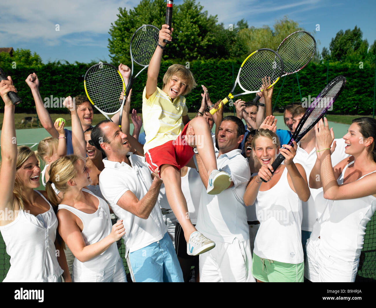 Persone che allevano il vincitore, campo da tennis Foto Stock