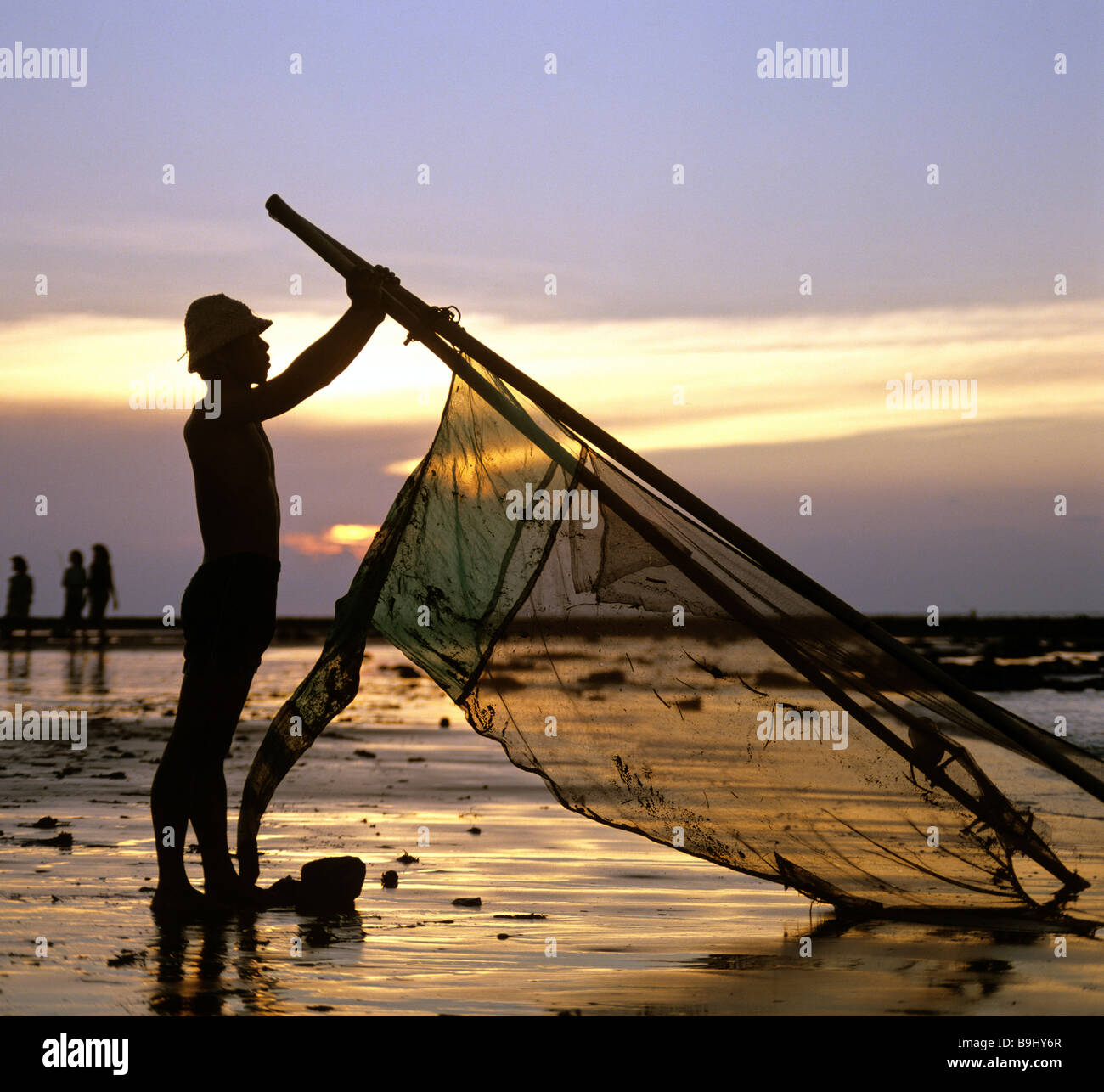 Pescatore con un net, oceano, luce della sera, Bali, Indonesia, sud-est asiatico Foto Stock