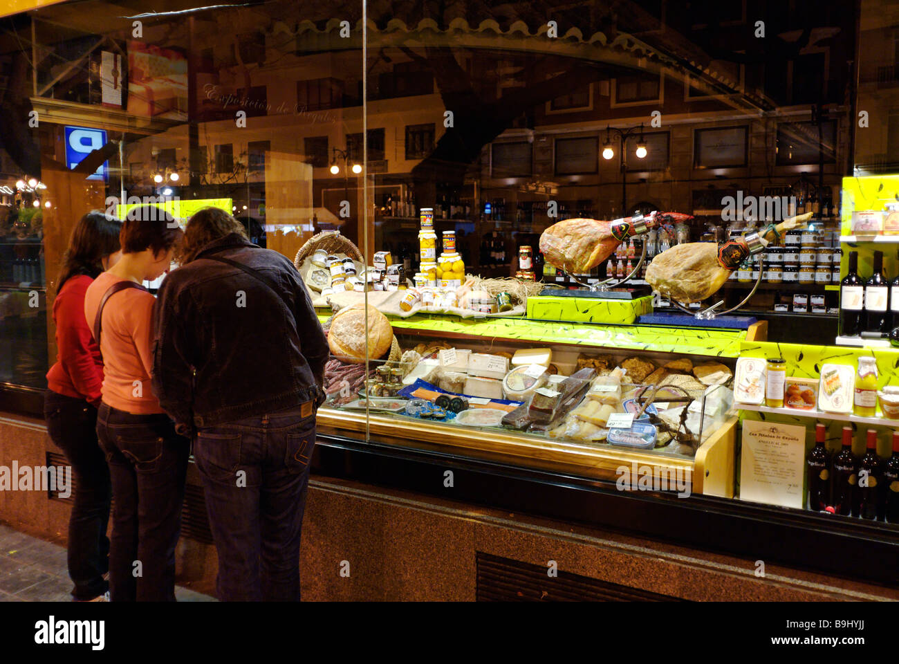 La gente di window shopping in spagnolo salumeria gourmet negozio di alimentari nel centro storico della città di Valencia Spagna Foto Stock