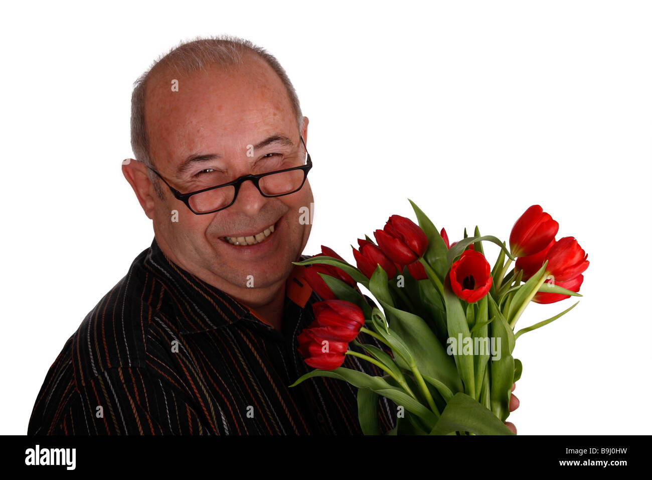 Ridendo titolare di pensione o di rendita che indossano occhiali e tenendo i tulipani Foto Stock