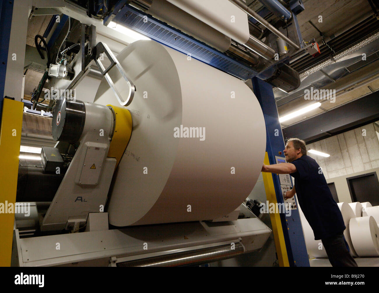 Dipendente a rullo la preparazione di rotoli di carta carta in magazzino di Badische Zeitung stampa, Freiburg im Breisgau, Baden-Wue Foto Stock