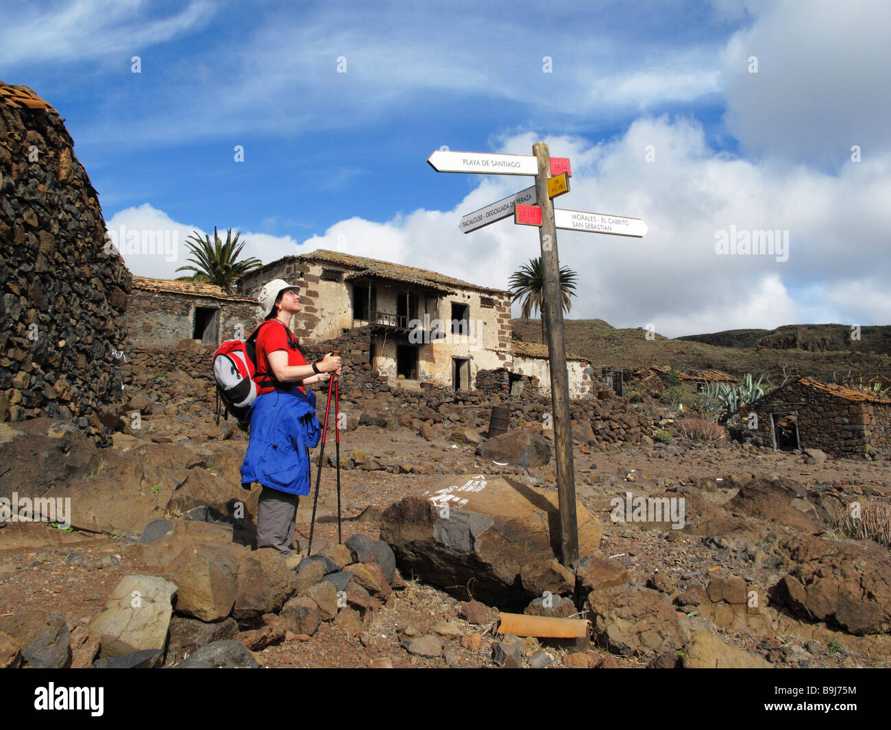 Escursionista, segnaletica e deserte le case di Contreras vicino a Playa Santiago, La Gomera, isole Canarie, Spagna, Europa Foto Stock