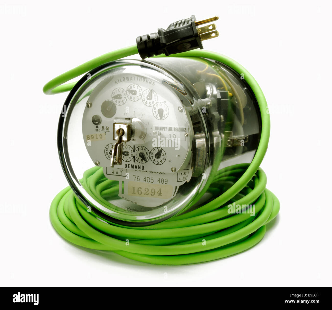 Contatore di energia su un verde avvolto a spirale prolunga elettrica cavo e spina Foto Stock