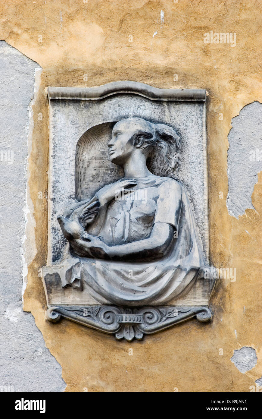 Una scultura in pietra di una donna e di una colomba della pace sull'esterno di un edificio nella Piazza del Mercato Vecchio (Stary Rynek), Poznan, Polonia Foto Stock
