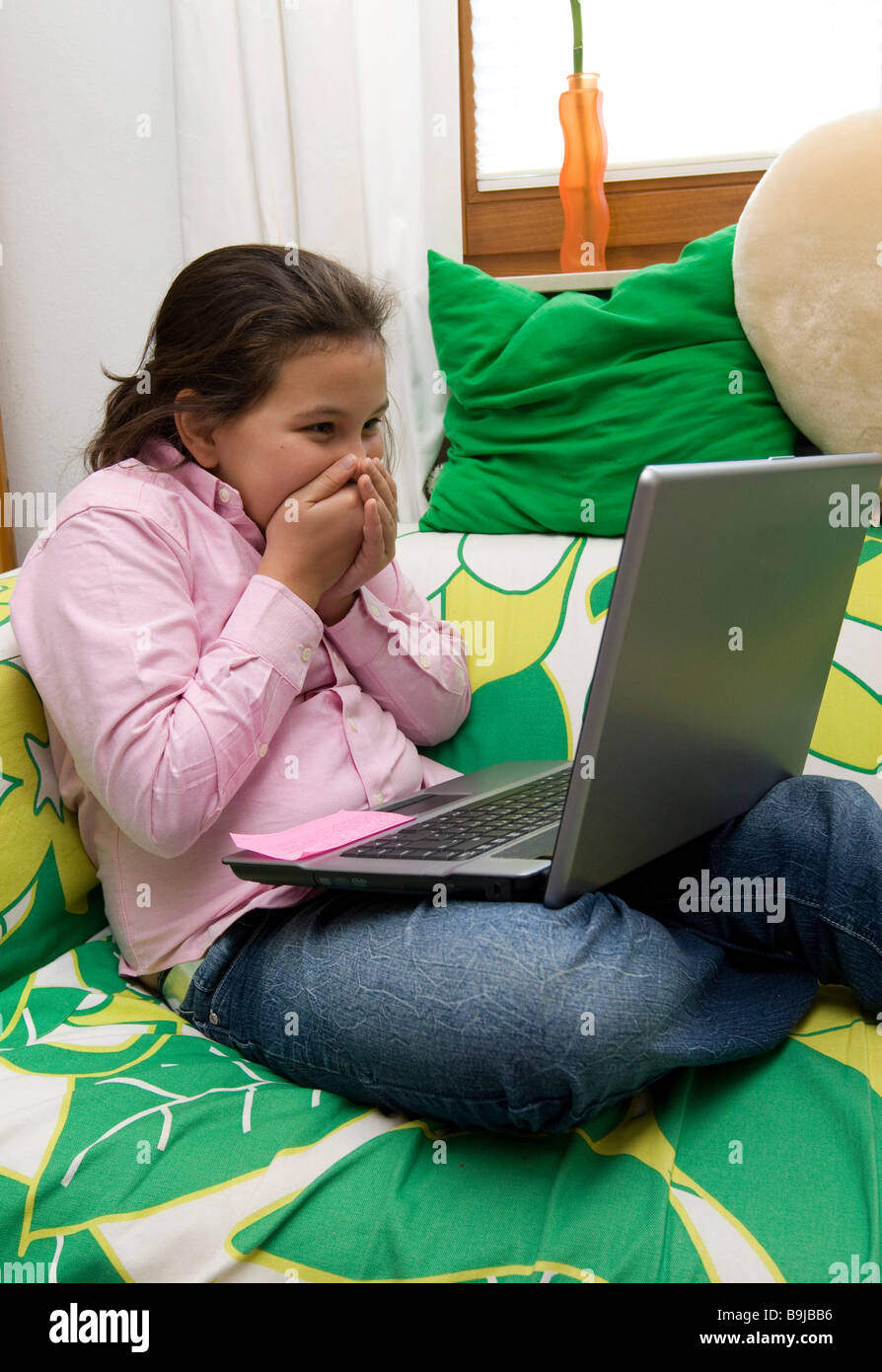 School girl, circa 11 anni, lavorando su un computer portatile, ha fatto una scoperta imbarazzante Foto Stock