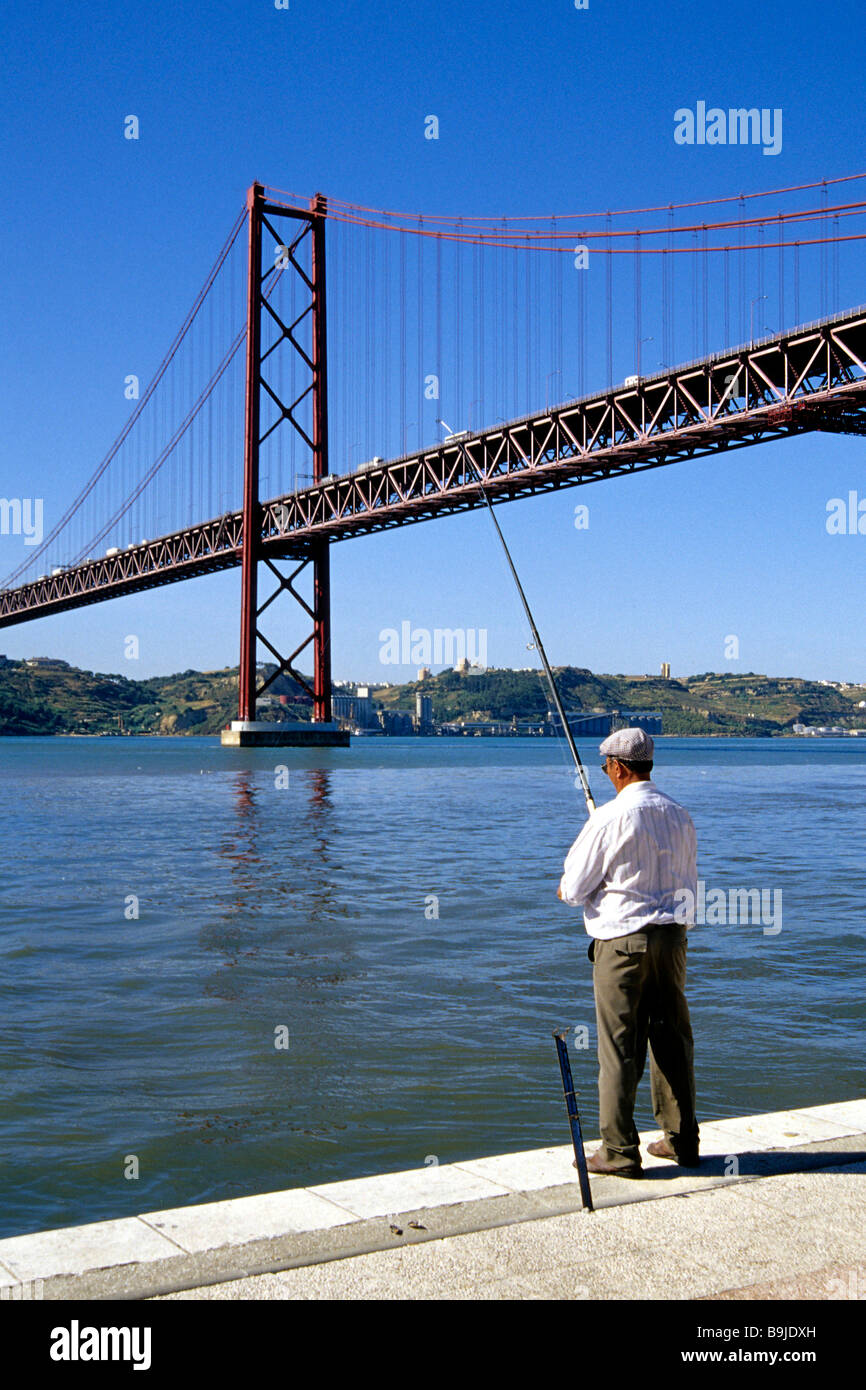 Doca de Santo Amaro, il pescatore a lungo il fiume Tejo, Ponte 25 de Abril in retro, ponte di sospensione, Alcantara, Lisbona, Porto Foto Stock