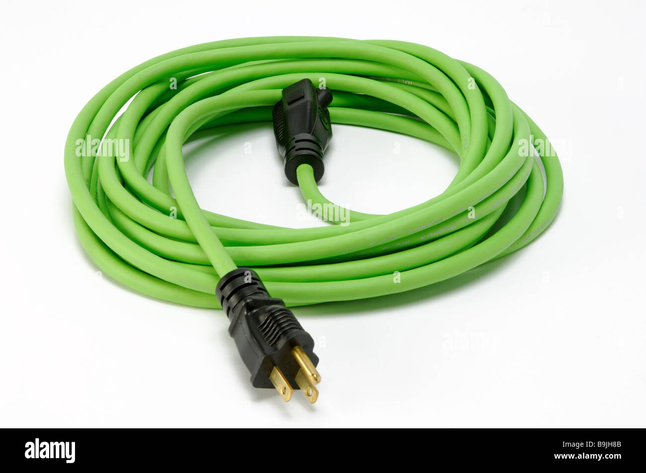 Un verde avvolto a spirale prolunga elettrica cavo di alimentazione con due tappi Foto Stock
