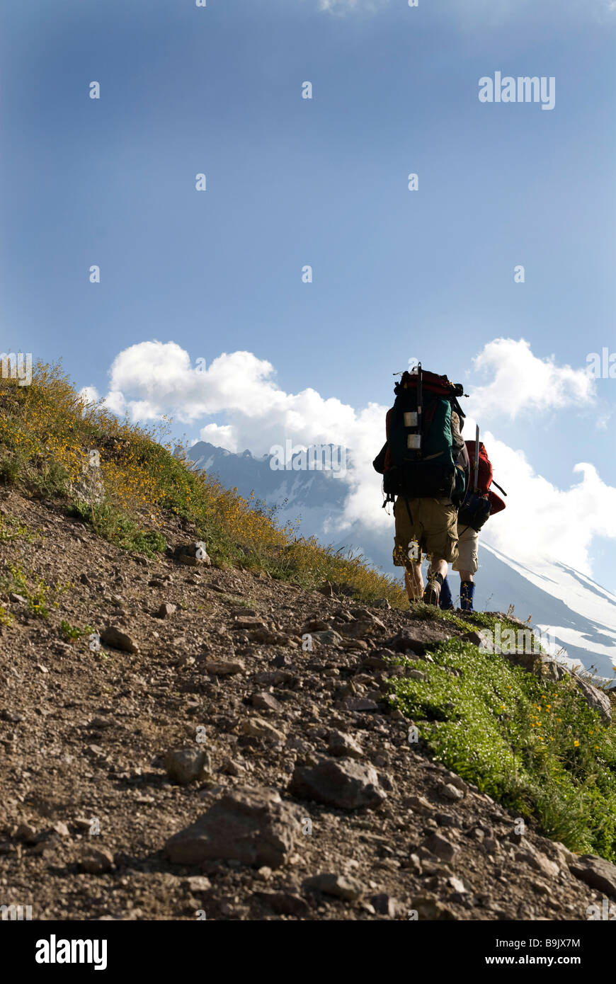 Due backpackers seguire un sentiero intorno a un lago alpino vicino al confine di Cile e Argentina. Foto Stock