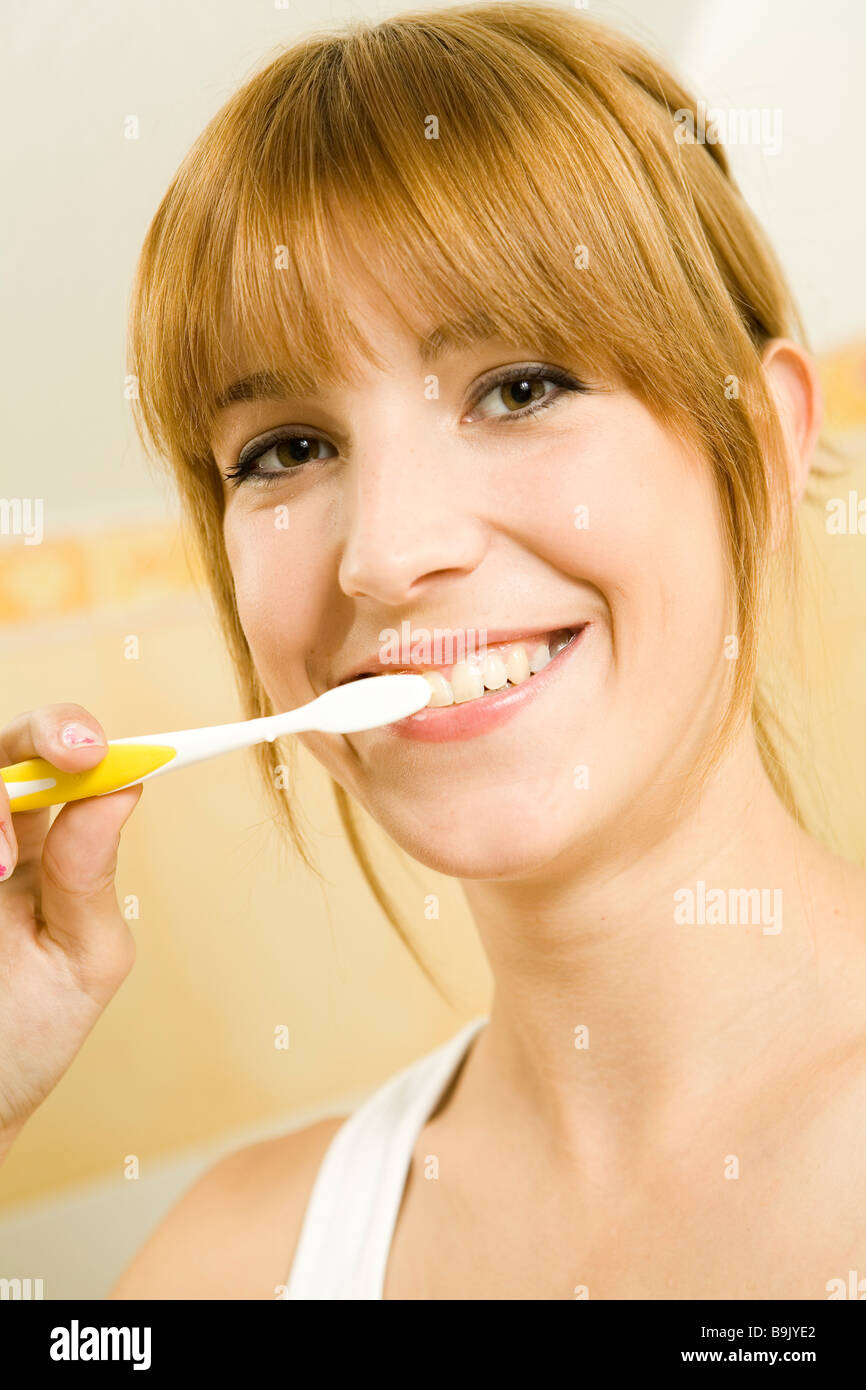 Giovane donna spazzolare i suoi denti Foto Stock