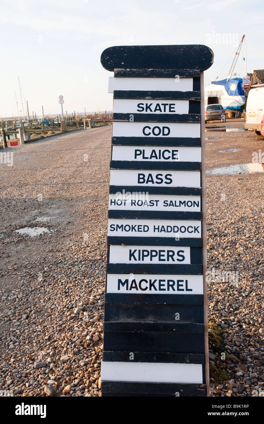 Pesce fresco segno al di fuori di un negozio nel porto di Southwold mostra Skate, il merluzzo bianco, passera di mare, Bass, con salmone, sgombro affumicato, eglefino e il salmone Foto Stock