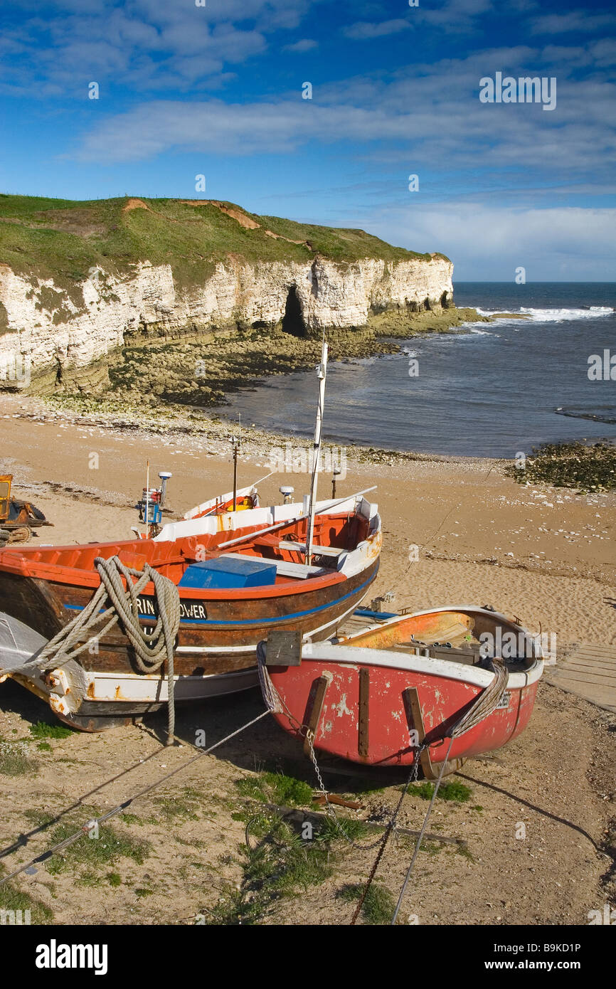 Barche da pesca ormeggiate a nord di atterraggio con spiaggia e scogliere di gesso al di là sul promontorio Flamborough Heritage Costa, Yorkshire Foto Stock