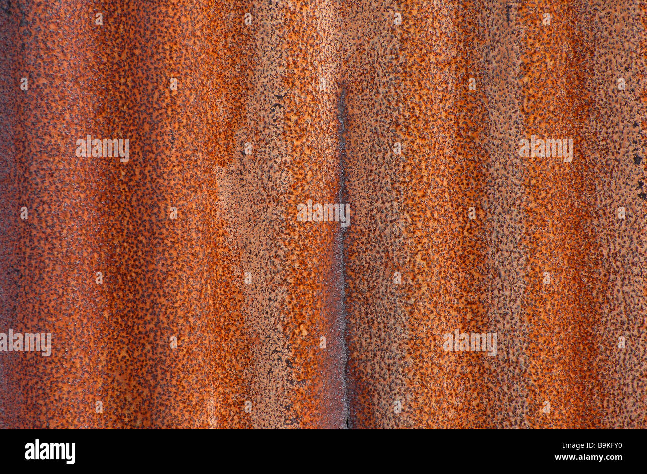 arrugginito ferro arrugginito dettaglio di texture rosse e mostrando le ondulazioni nel metallo creando uno sfondo astratto Foto Stock