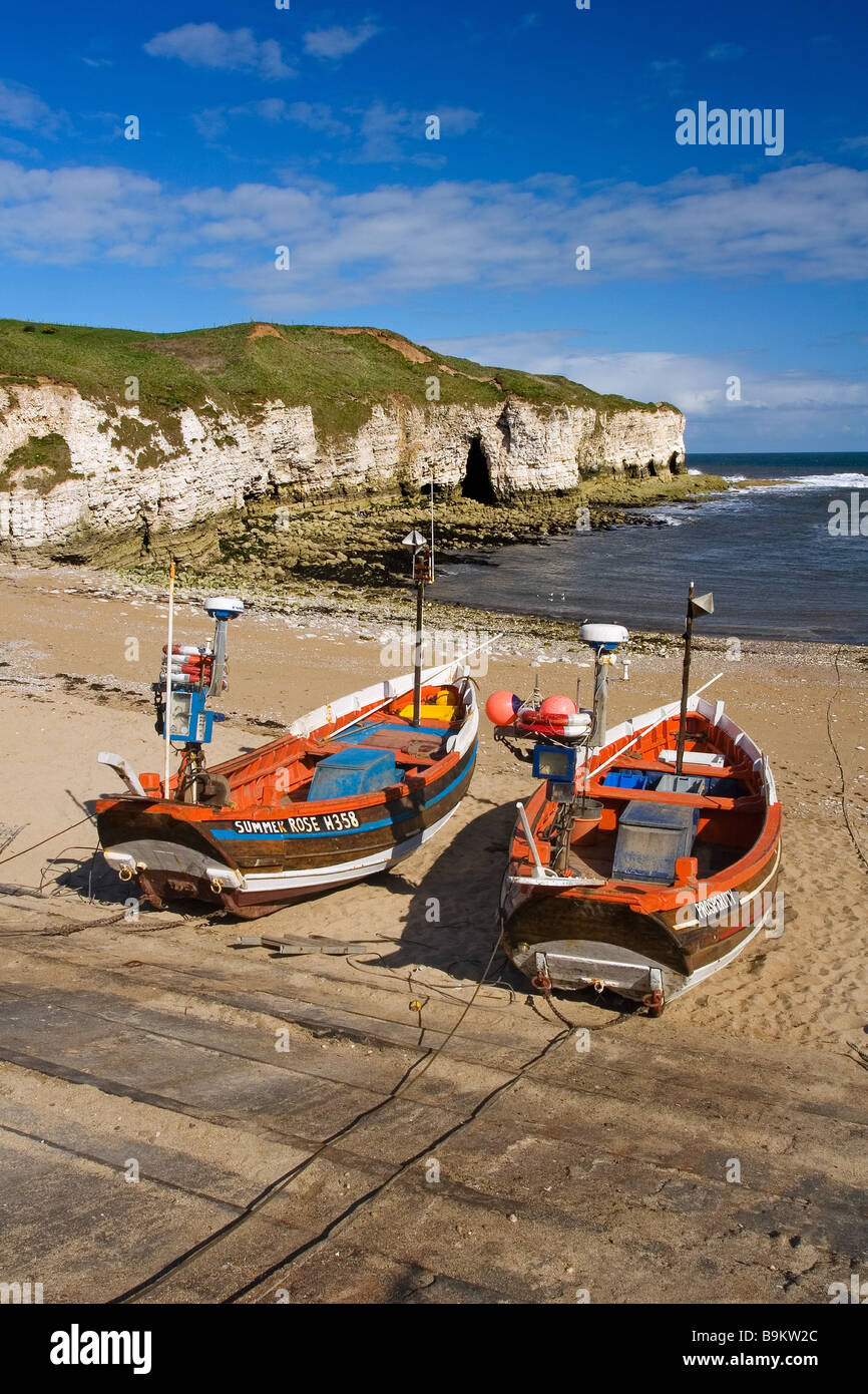 Barche da pesca ormeggiate a nord di atterraggio con spiaggia e scogliere di gesso al di là sul promontorio Flamborough Heritage Costa, Yorkshire Foto Stock