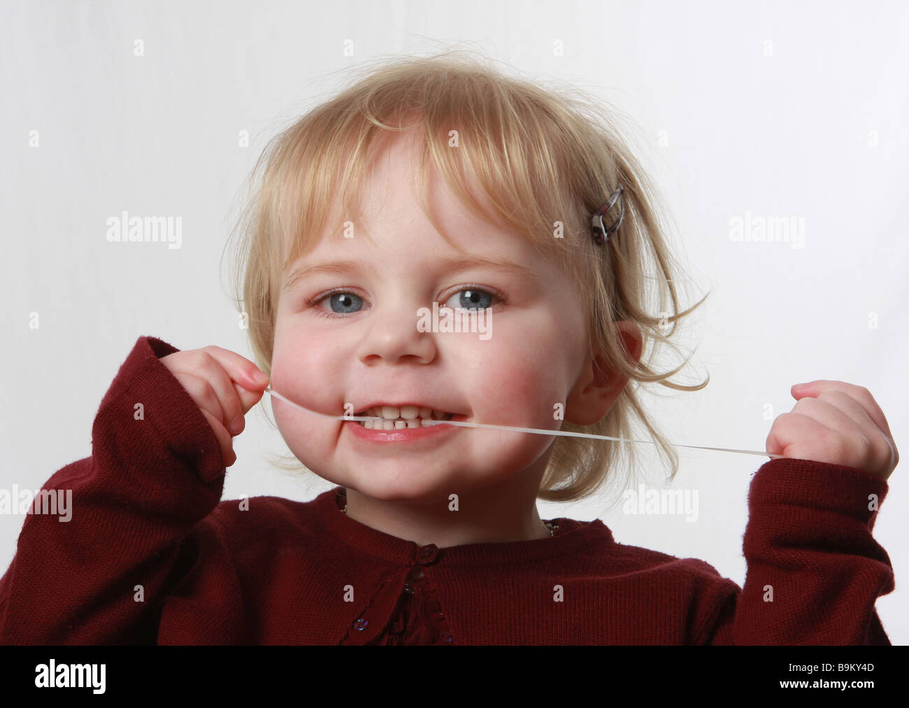 Una piccola ragazza utilizza il filo interdentale filo interdentale bambino il filo interdentale dentista denti ragazza utilizzando il filo interdentale Foto Stock