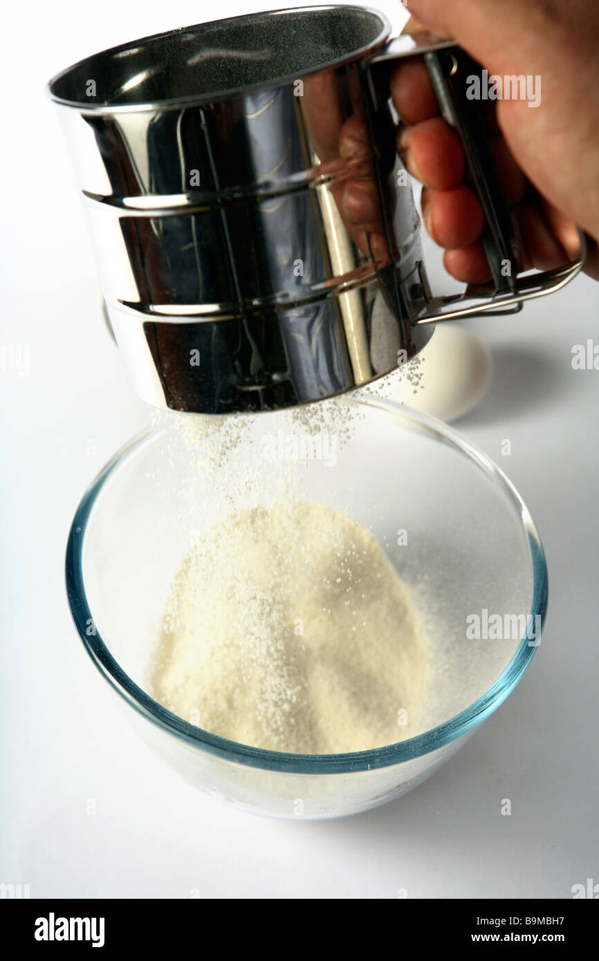 Setacciare la farina in un recipiente di vetro,con un uovo in background  Foto stock - Alamy