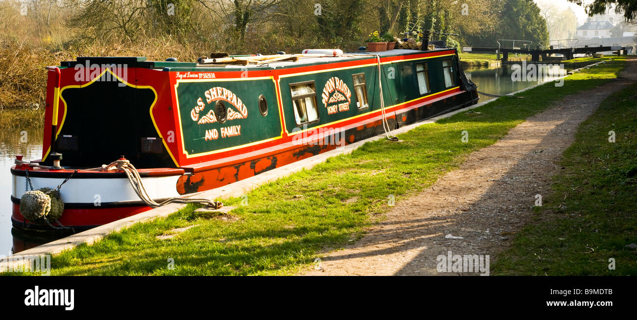 Un narrowboat ormeggiate lungo il Kennet and Avon Canal a Hungerford Berkshire England Regno Unito con serratura a Hungerford in distanza Foto Stock