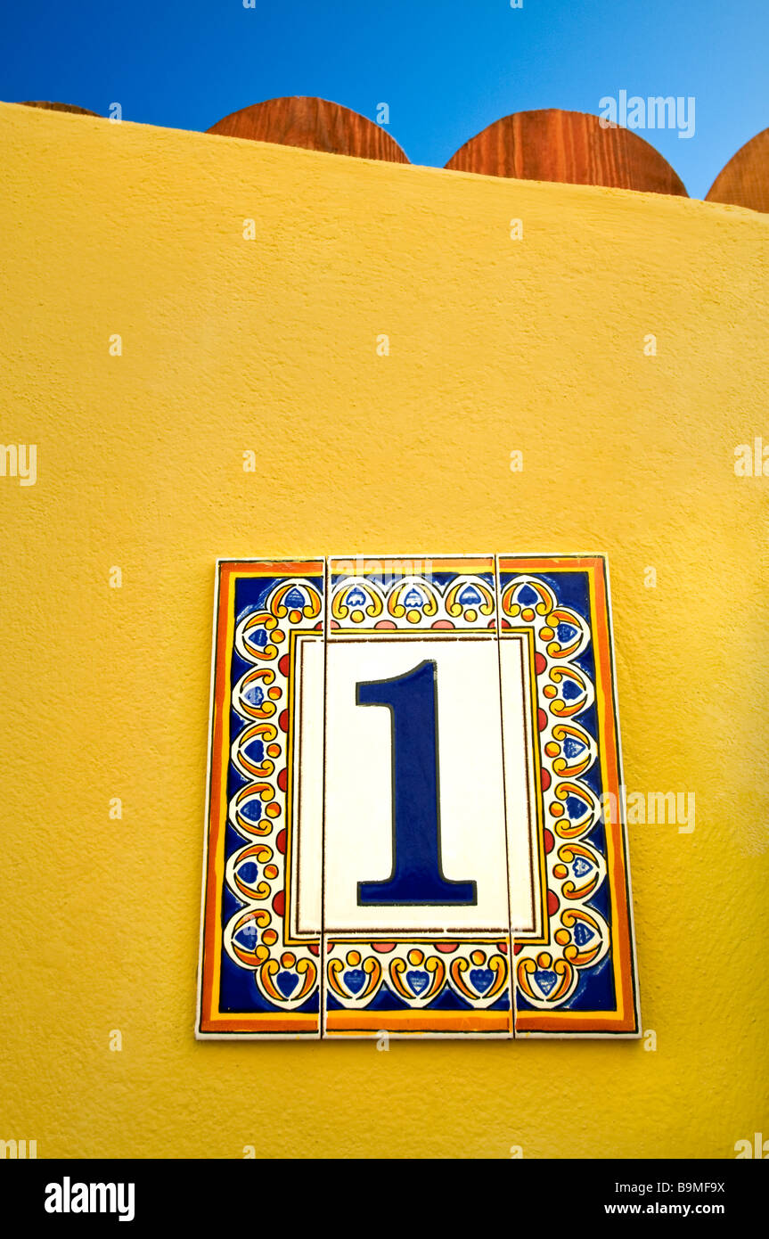 Il numero uno di villa la parete di piastrelle in ceramica piastrelle decorative "numero 1" sulla parete gialla al di fuori di sunny holiday vacation resort villa mediterranea appartamento Foto Stock