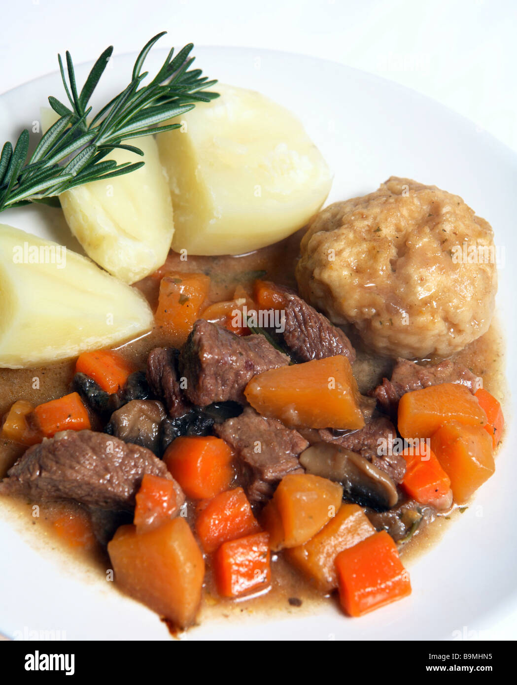 Un tipico in stile inglese di stufato di manzo,contenenti carote,svedese (rutabaga) e funghi, con suet e gnocco di patate bollite. Foto Stock