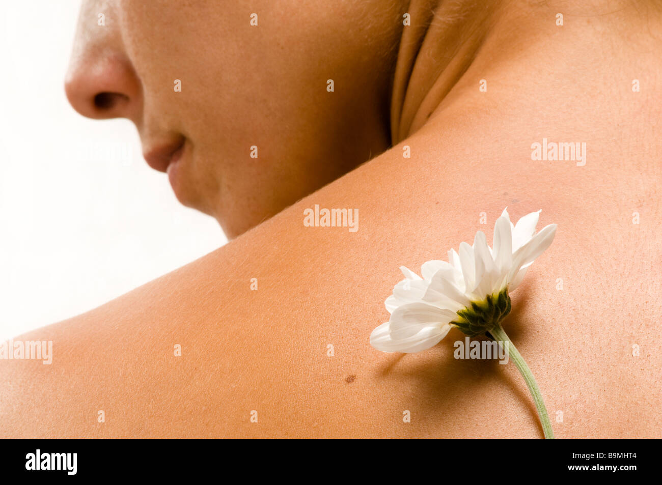 Donna con la schiena con fiore bianco Foto Stock