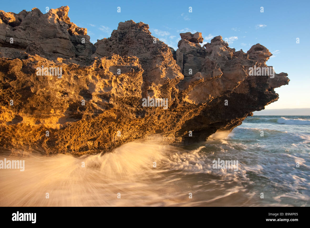Un'onda pounding roccia calcarea, Trigg Beach a Perth in Australia. Un esempio di erosione costiera. Foto Stock