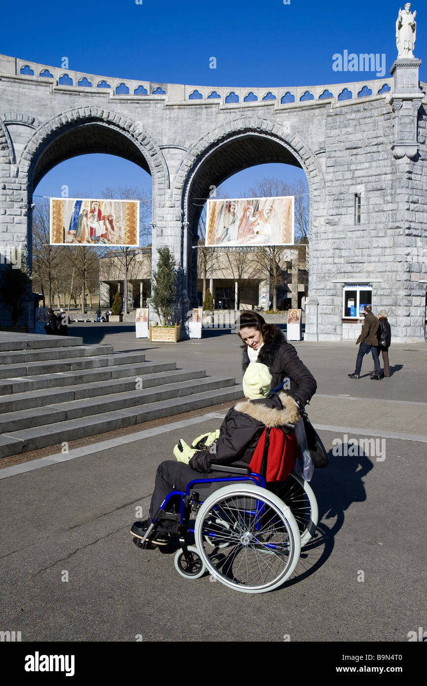Francia, Hautes Pirenei, Lourdes, pellegrina in sedia a rotelle sul sagrato della spianata che conduce ai santuari, le foto scattate Foto Stock