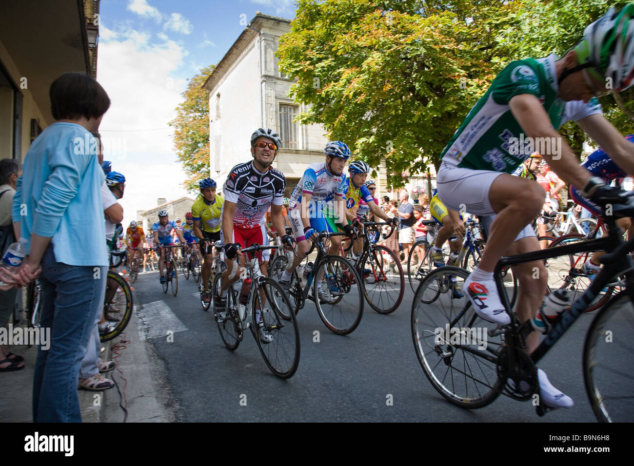 Il gruppetto di ciclisti spostare off all'inizio di una gara in Villefranche de Lonchat, Francia. Foto Stock