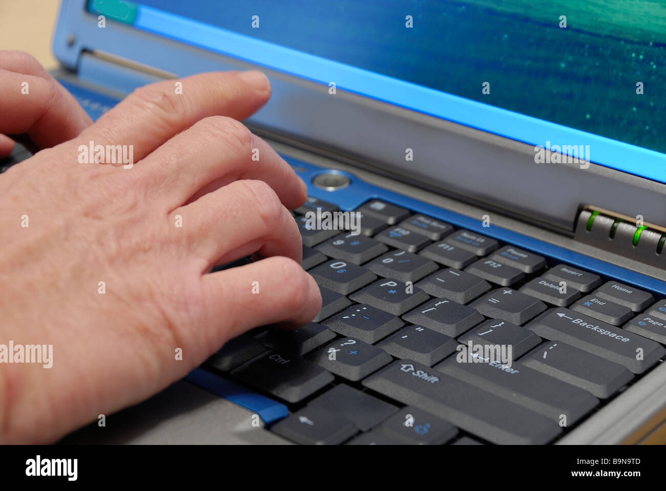 Persona che immette i dati su una tastiera in un computer portatile Foto Stock