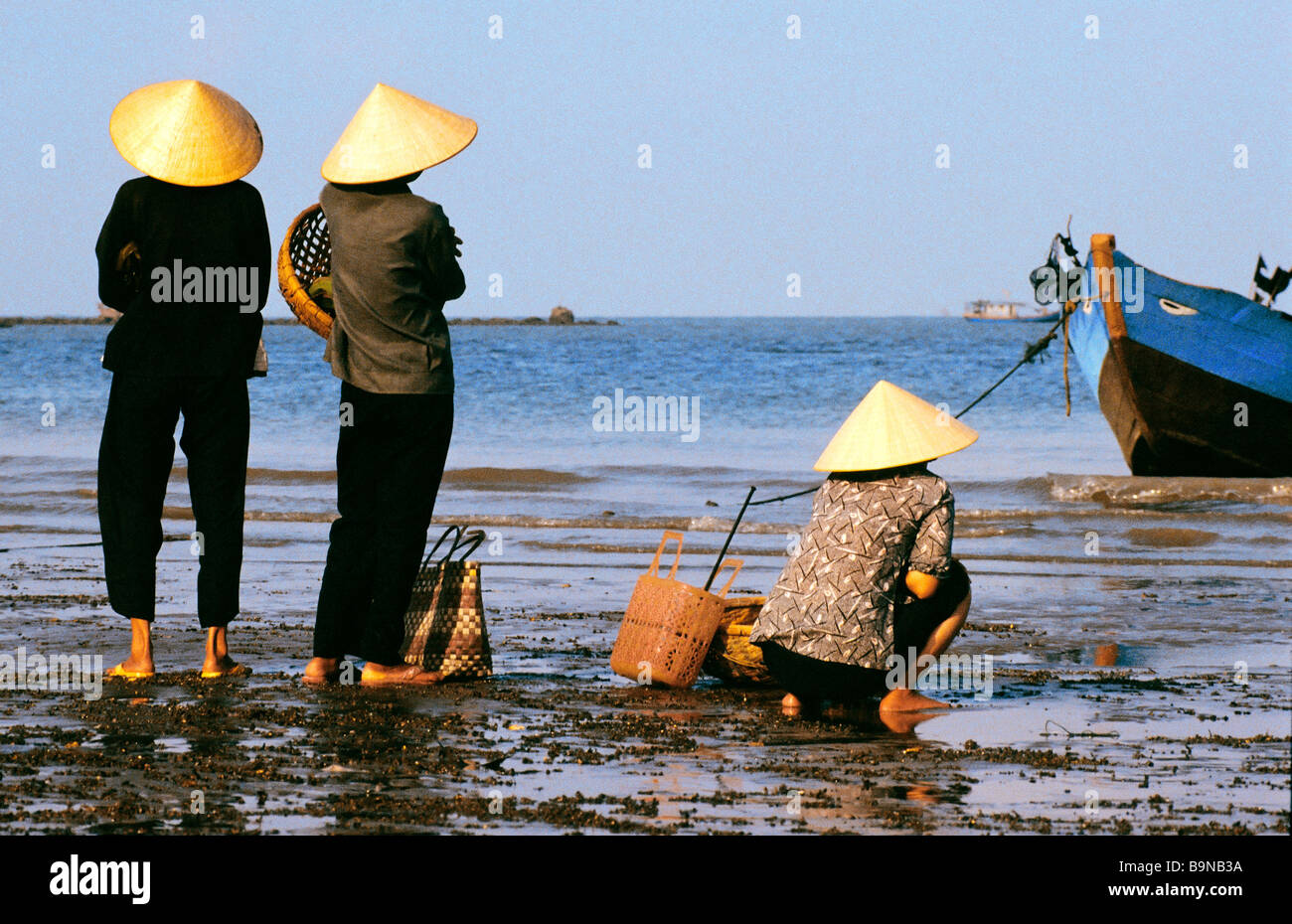 Il Vietnam, Ba Ria-Vung Tau provincia, Vung Tau, pescatori mogli in attesa per il ritorno delle barche per sbarcare il pesce Foto Stock