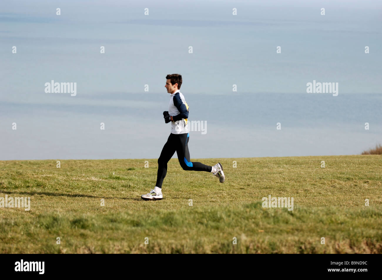 Un runner out allenamento lungo le scogliere vicino Beachy Head in East Sussex Regno Unito Foto Stock