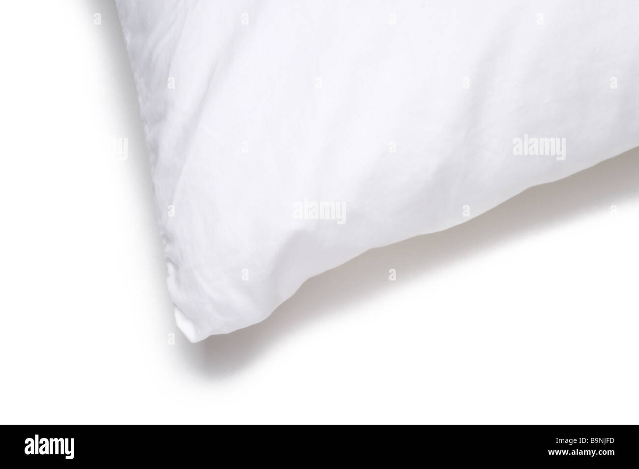 Spigolo di un letto bianco cuscino su sfondo bianco Foto Stock