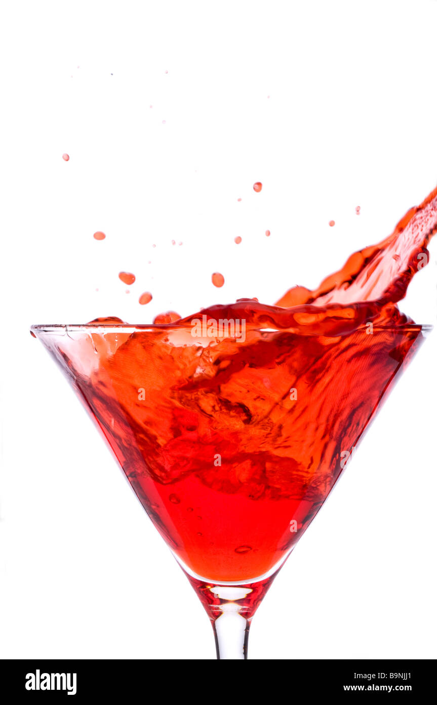 Un cubo di ghiaccio spalshing in un martini rosso bevanda alcolica Foto Stock