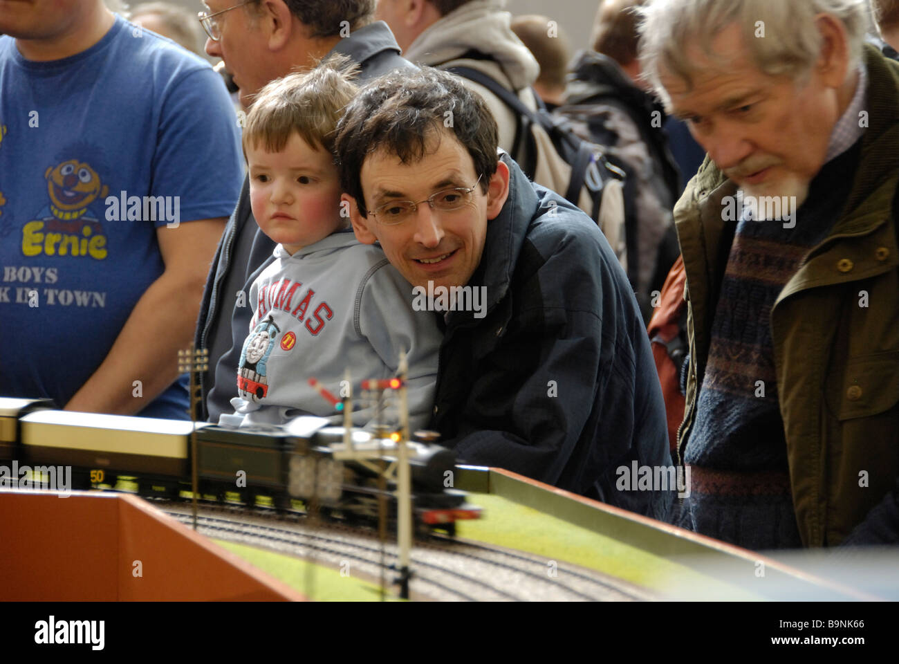 Padre e figlio giovane orologio modello treni passano da al modello mostra ferroviaria Foto Stock