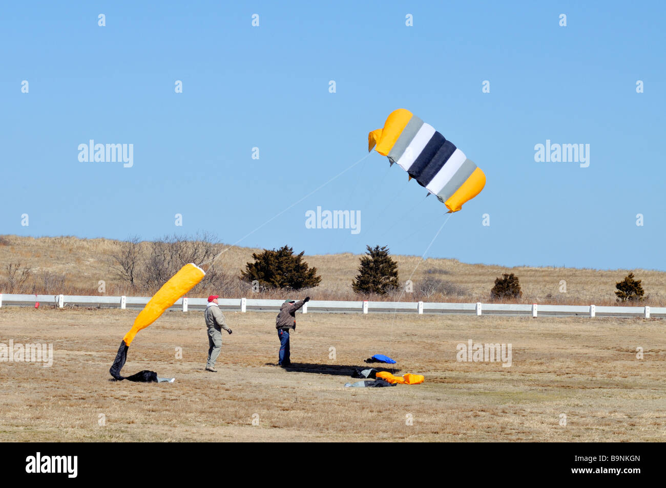 2 due uomini iniziano a volare un grande [sled kite] Foto Stock