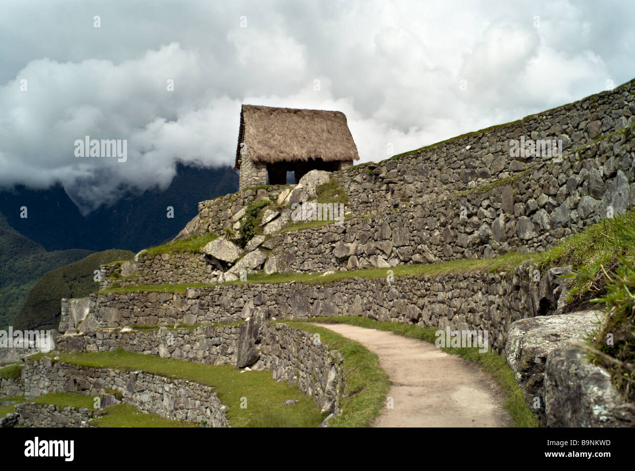 Il Perù MACHU PICCHU Capanna del custode di roccia funeraria è uno dei pochi edifici che ha ripristinato un tetto di paglia Foto Stock