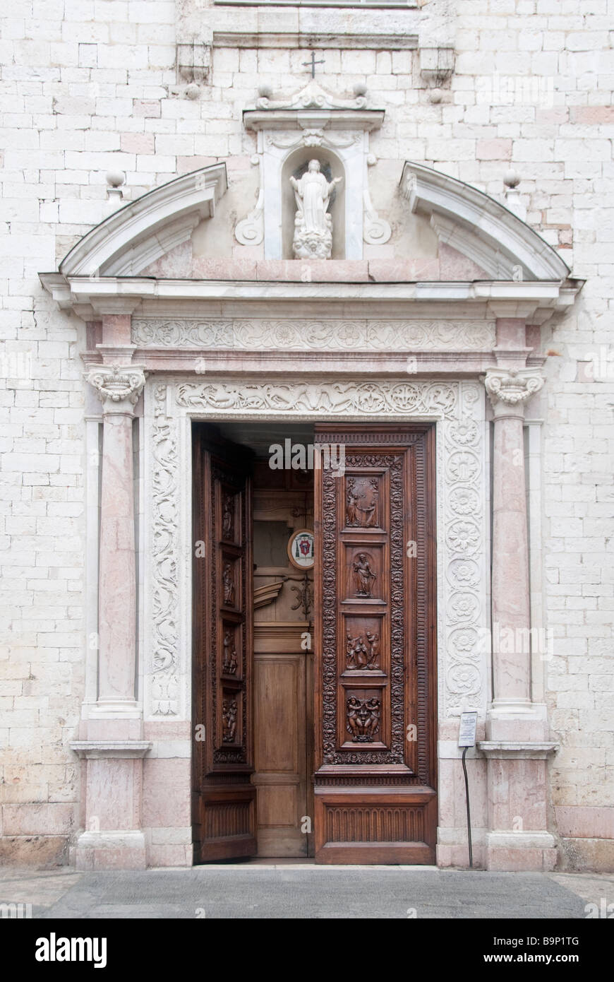 Porta della Chiesa di Santa Maria Maggiore a Spello con rosa travetine marmo scavati dal vicino Monte Subasio Foto Stock