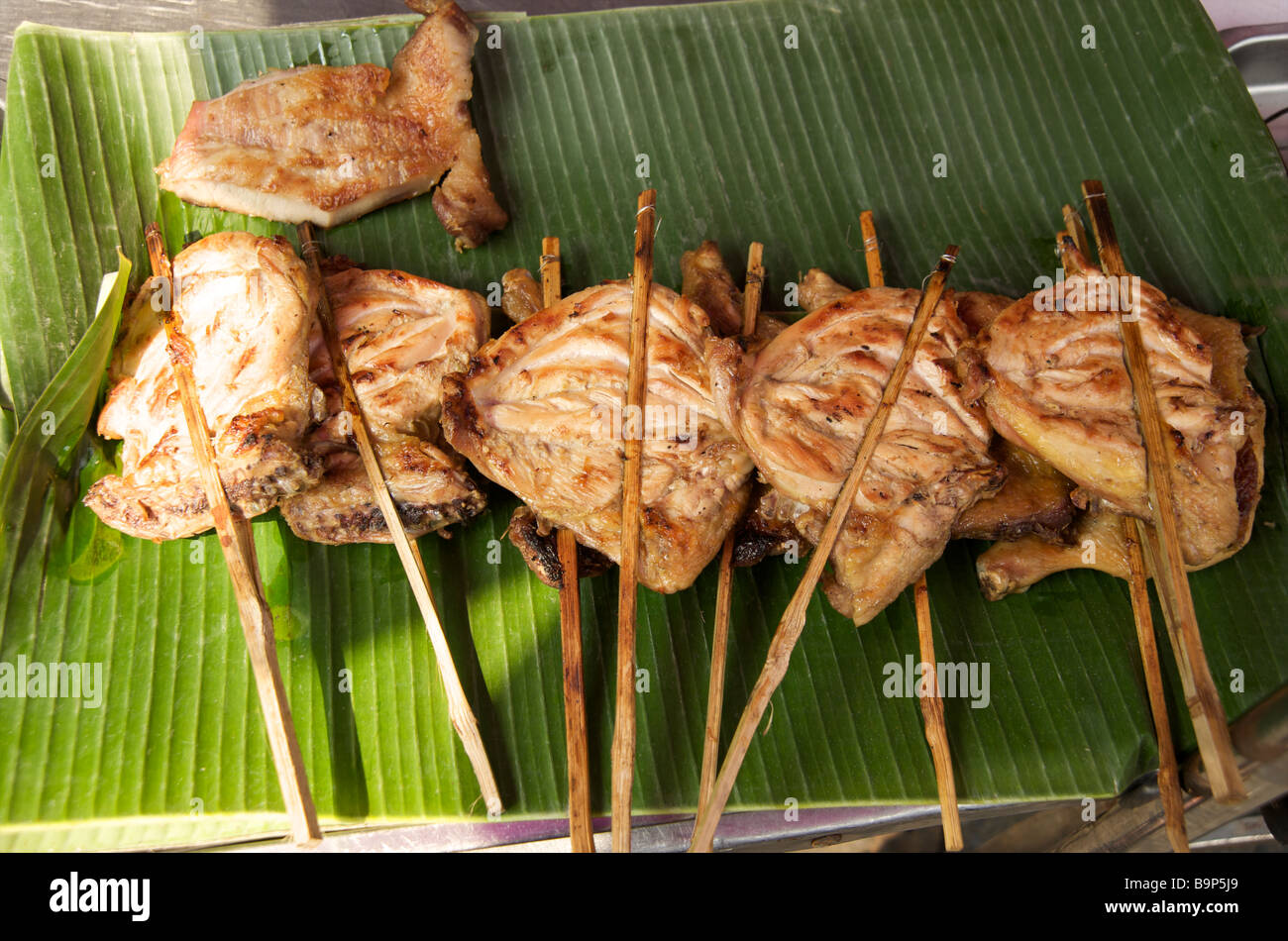 Primo piano di pezzi di pollo spiedati al barbecue in una bancarella di Bangkok Foto Stock