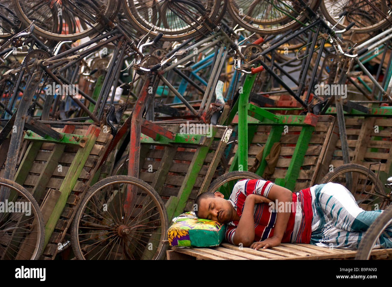 In rickshaw uomo dorme duro lavoro Foto Stock