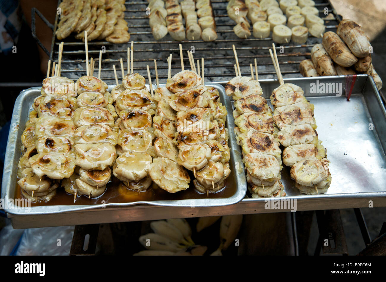 Primo piano di banane spiedate spiedate al barbecue in una bancarella di Bangkok Foto Stock