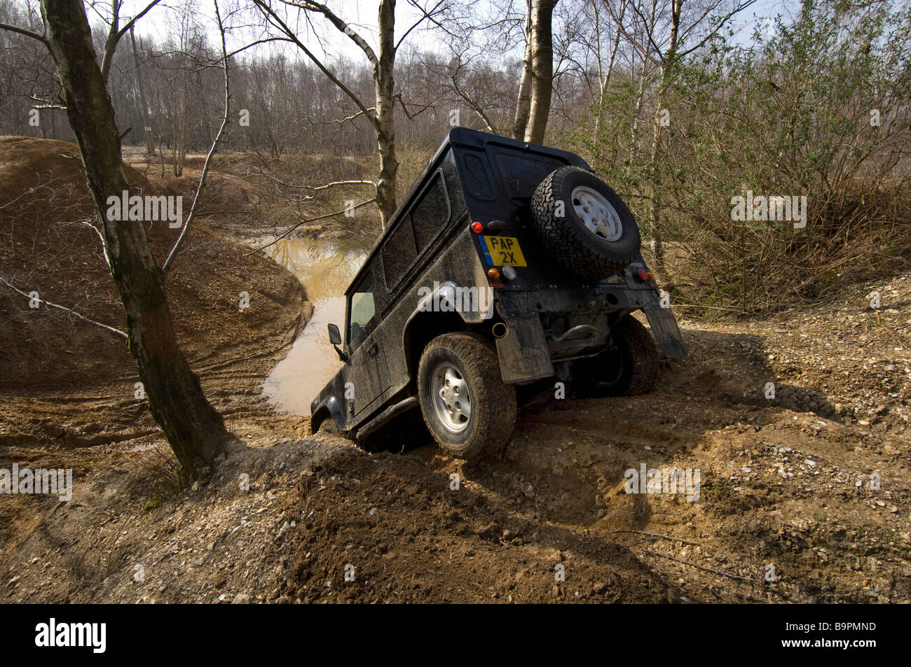 Il design 2007 Land Rover Defender 90 si muove verso il basso una sponda ripida ad un laghetto in Slindon West Sussex Regno Unito durante un esercizio su strada. Foto Stock