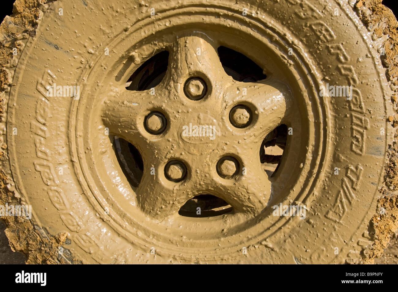 Il fangoso ruota di un Land Rover Defender 90 dopo aver guidato attraverso una strada allagata Foto Stock